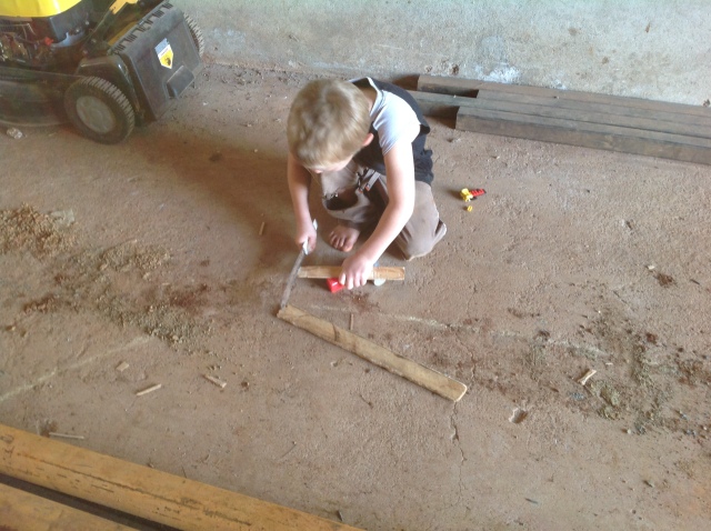 Colin cut wood pieces with a file to make a form for the bricks.